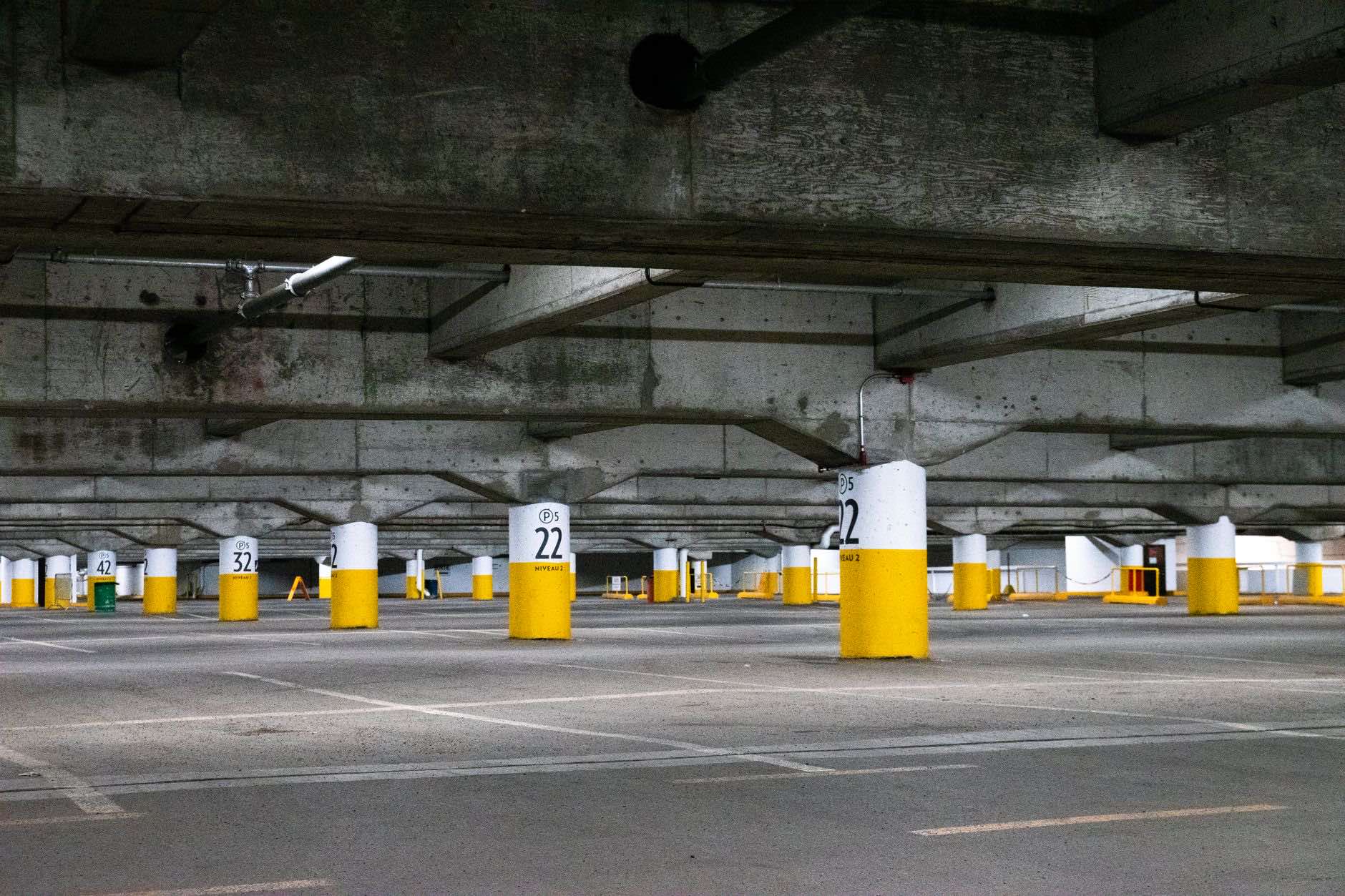 A parking deck with numbered concrete columns marking the bays