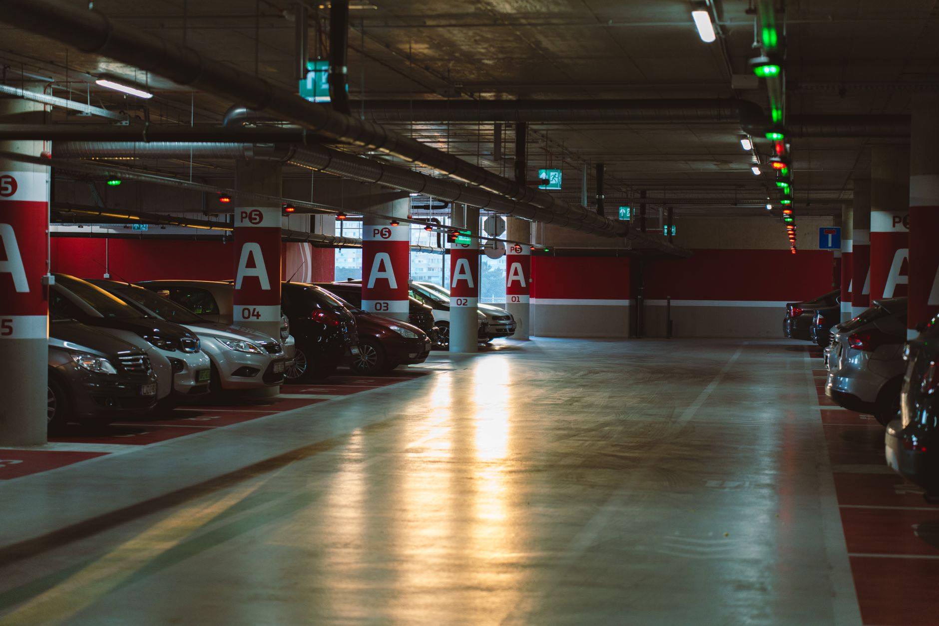 A lit underground parking level with the bays marked by letter and number
