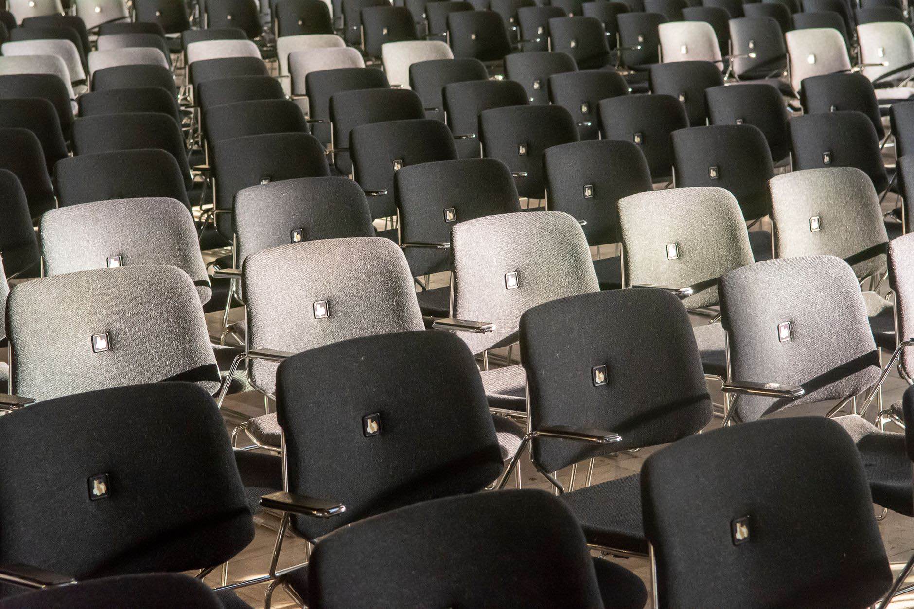 Rows of empty seats in an auditorium, seen from the side
